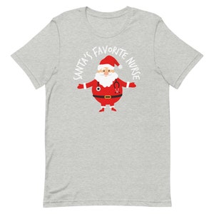 May include: A grey t-shirt with a white graphic of Santa Claus wearing a stethoscope and the text "Santa's Favourite Nurse".