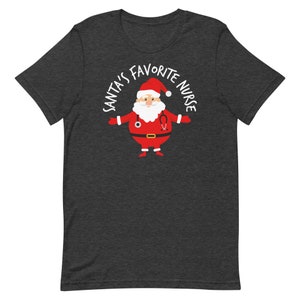May include: Dark heather grey t-shirt featuring a cartoon Santa Claus wearing a stethoscope and the text "Santa's Favourite Nurse".