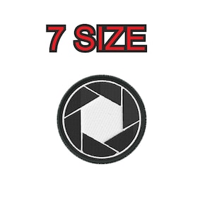 Op de afbeelding: Zwart-wit camera diafragma symbool met een wit centrum. Het symbool is omgeven door een zwarte cirkel met een dunne zwarte omtrek. De tekst "7 SIZE" staat boven het symbool in rood.