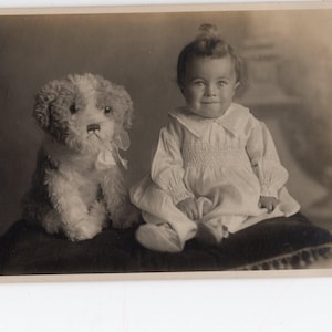 Foto antica di un bambino o di un cane giocattolo - cane di peluche, cane di peluche, bambino piccolo, ritratto di famiglia, bambini, bambina o bambino carino, foto in bianco e nero