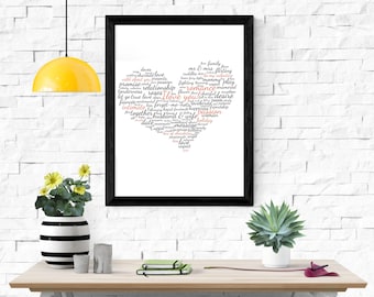 Puede incluir: Un cuadro enmarcado con un diseño en forma de corazón compuesto por palabras relacionadas con el amor y las relaciones. Las palabras son en negro y rojo, con "I love you" resaltado. El marco es negro, sobre una mesa de madera.