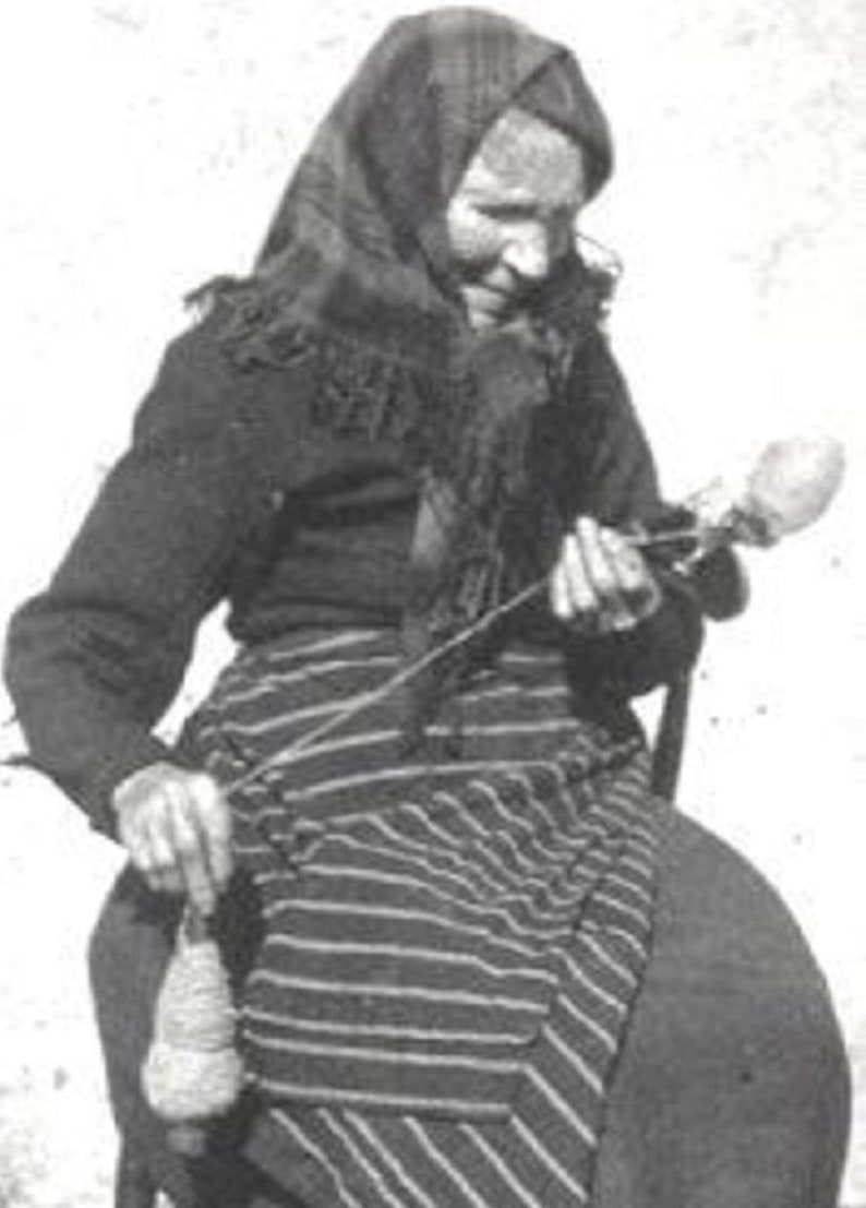 May include: A woman wearing a headscarf and a striped skirt spins yarn with a spinning wheel.