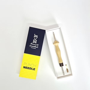Pode incluir: Um conjunto de ferramentas de agulha de perfuração em uma caixa branca, com uma caixa estampada em azul marinho e amarelo. A agulha de perfuração tem um cabo de madeira clara e uma agulha de metal. A caixa diz "LOVOR tricot crochet PORTUGAL" e "PUNCH NEEDLE".