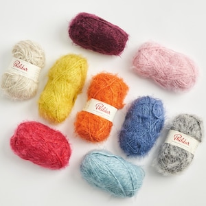 Pode incluir: Uma caneca de cerâmica branca com uma alça preta e o texto "But First, Coffee" em preto, com uma fonte manuscrita. A caneca está sobre uma superfície branca.