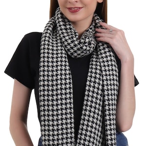 May include: A black and white houndstooth patterned scarf. The scarf is made of a soft, lightweight fabric and is perfect for adding a touch of style to any outfit.