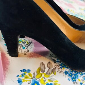 Puede incluir: Un par de zapatos de tac&oacute;n alto de ante negro con punta.