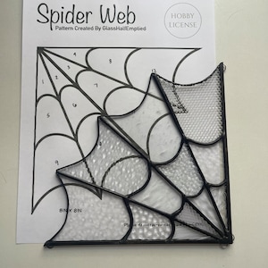 Könnte beinhalten: Ein schwarz-weißes Spinnennetz-Fensterbild mit dem Text "Spider Web" und "Pattern Created By GlassHalfEmptied" oben. Das Muster ist 8 Zoll mal 8 Zoll groß.