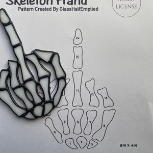 May include: A black and white line art pattern of a skeleton hand giving the middle finger. The pattern is numbered 1 through 16. The pattern is 6 inches by 4 inches. The text "Hobby License" is in the upper right corner of the image. The text "Please do not recreate or share this pattern." is at the bottom of the image.
