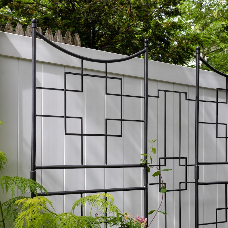 May include: Black metal garden trellis with a geometric design. The trellis is made of sturdy metal and has a black finish. It is perfect for adding a touch of elegance to your garden.