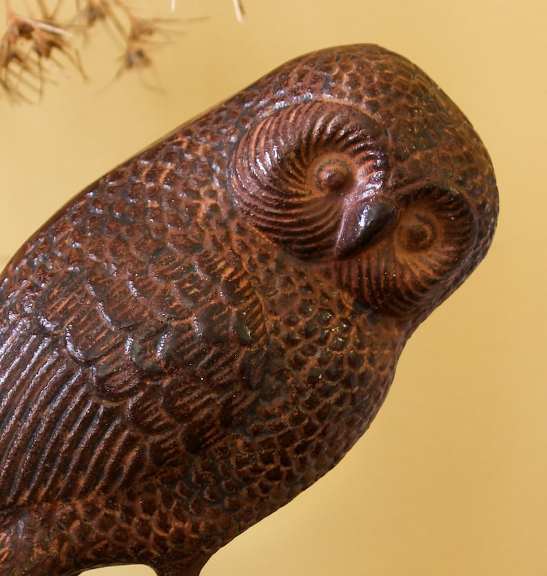 May include: A brown cast iron owl figurine with detailed feathers and a textured surface.