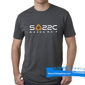 May include: A dark gray t-shirt with a white graphic of a rotary engine and the text "S022C MAZDA RX-7".