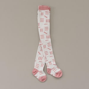 May include: White tights with a pink geometric pattern. The tights have a pink band at the top and pink toes.