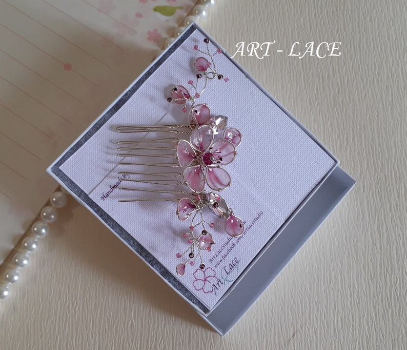 A delicate pink flower hair comb in silver finish, Japanese Kanzashi style, The central flower size 3 cm diameter. Around that is a cluster of petals, crystals and tiny seed beads. Handmade wire resin pink flowers and petals.