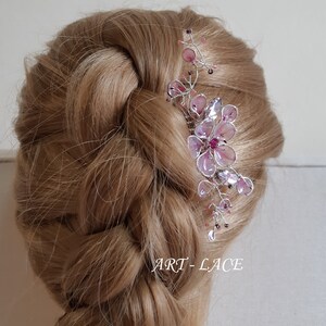 A delicate pink flower hair comb in silver finish, Japanese Kanzashi style, The central flower size 3 cm diameter. Around that is a cluster of petals, crystals and tiny seed beads. Handmade wire resin pink flowers and petals.