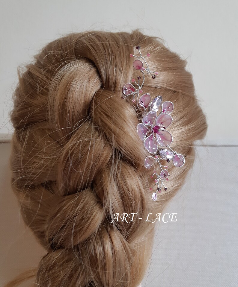 A delicate pink flower hair comb in silver finish, Japanese Kanzashi style, The central flower size 3 cm diameter. Around that is a cluster of petals, crystals and tiny seed beads. Handmade wire resin pink flowers and petals.