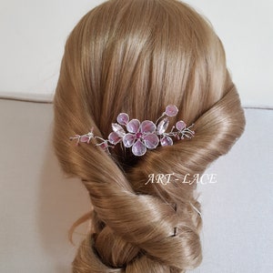 A delicate pink flower hair comb in silver finish, Japanese Kanzashi style, The central flower size 3 cm diameter. Around that is a cluster of petals, crystals and tiny seed beads. Handmade wire resin pink flowers and petals.