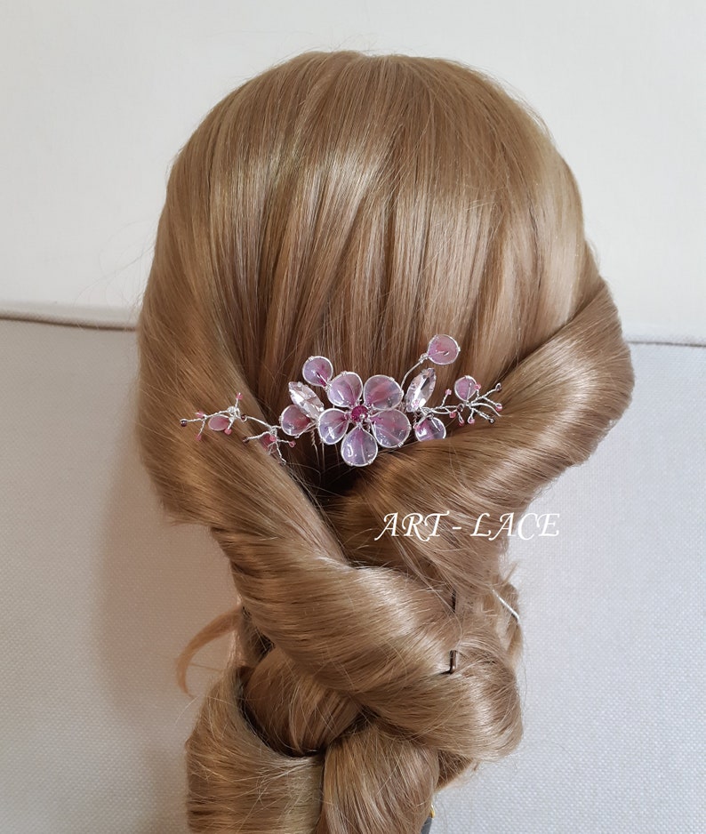 A delicate pink flower hair comb in silver finish, Japanese Kanzashi style, The central flower size 3 cm diameter. Around that is a cluster of petals, crystals and tiny seed beads. Handmade wire resin pink flowers and petals.