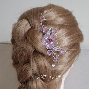 A delicate pink flower hair comb in silver finish, Japanese Kanzashi style, The central flower size 3 cm diameter. Around that is a cluster of petals, crystals and tiny seed beads. Handmade wire resin pink flowers and petals.