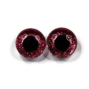 May include: Two red glitter safety eyes with black pupils. The eyes are round and have a shiny finish.