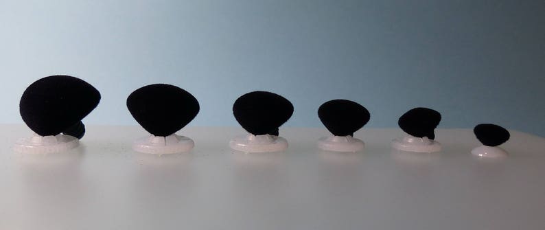 K&ouml;nnte beinhalten: Ein Set mit sieben schwarzen Samtringst&auml;ndern in verschiedenen Gr&ouml;&szlig;en, jeweils mit einem wei&szlig;en Sockel.