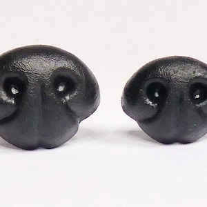 May include: Two black plastic animal noses, one larger than the other. Both have two holes for nostrils.