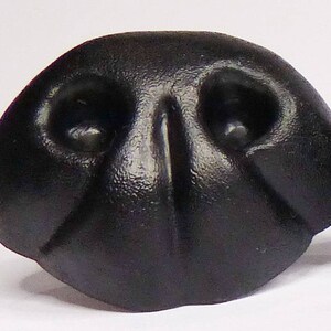 May include: A black rubber dog nose, designed for use in crafts and costume making.