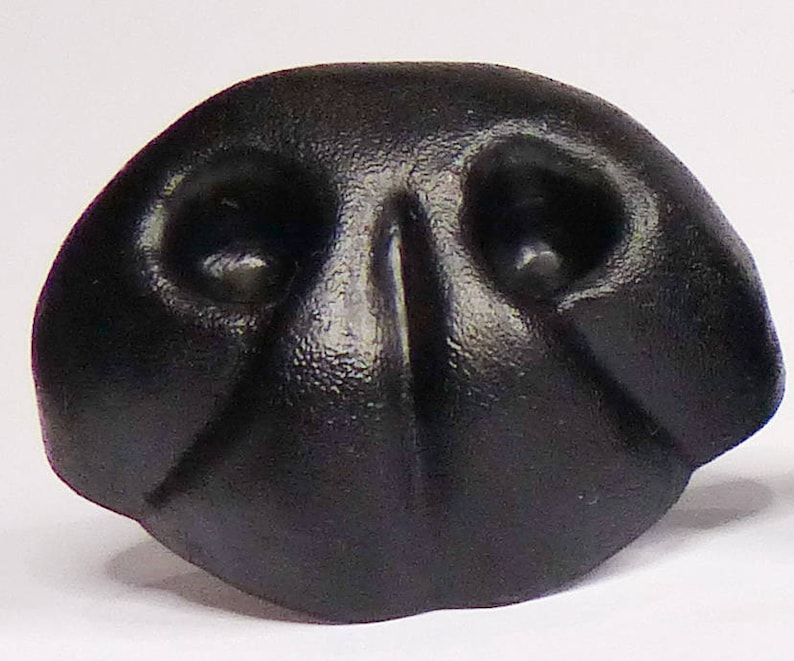 May include: A black rubber dog nose, designed for use in crafts and costume making.
