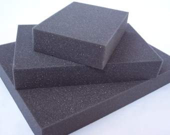 May include: Three pieces of black foam padding stacked on top of each other. The foam is textured and has a slightly rough surface.