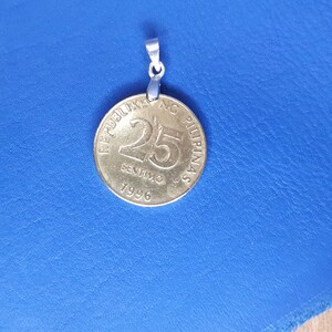 May include: A silver pendant featuring a 25-centavo coin from the Philippines. The coin is dated 1996 and has the text "REPUBLIKA NG PILIPINAS" around the edge.