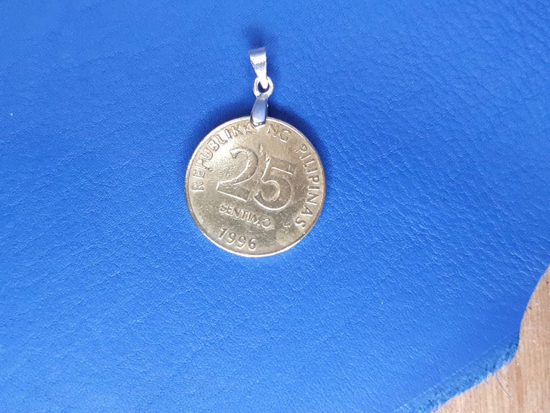 May include: A silver pendant featuring a 25-centavo coin from the Philippines. The coin is dated 1996 and has the text "REPUBLIKA NG PILIPINAS" around the edge.