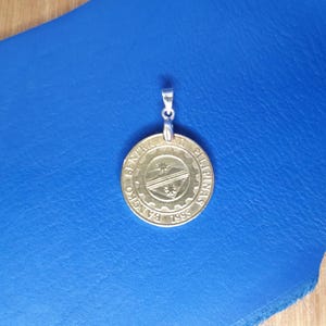 May include: A gold-coloured coin pendant with the text "Bangko Sentral ng Pilipinas 1998" and a stylised image of a ship.