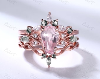 May include: A rose gold ring set with a large pink gemstone surrounded by smaller clear and green gemstones. The ring has a delicate, intricate design.