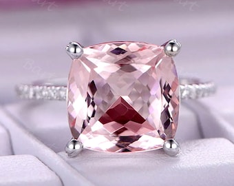 May include: A pink cushion-cut gemstone ring with a diamond halo and a silver band.