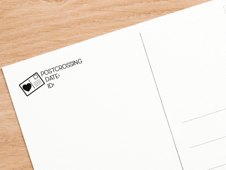 May include: A white postcard featuring a black ink stamp in the upper left corner. The stamp design includes a small rectangular icon with a heart, followed by the text POSTCROSSING, DATE:, and ID: printed in a clean, sans-serif black font.