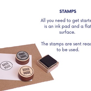 May include: Two wooden stamps with the text "HAND MADE" in black ink, one with a gray background and one with a natural wood background. A black ink pad is also shown.