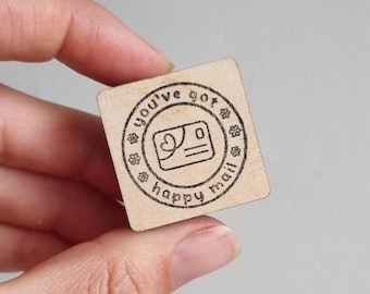 May include: A wooden stamp with a circle design that says "You've got happy mail" with a small envelope and heart icon inside the circle.
