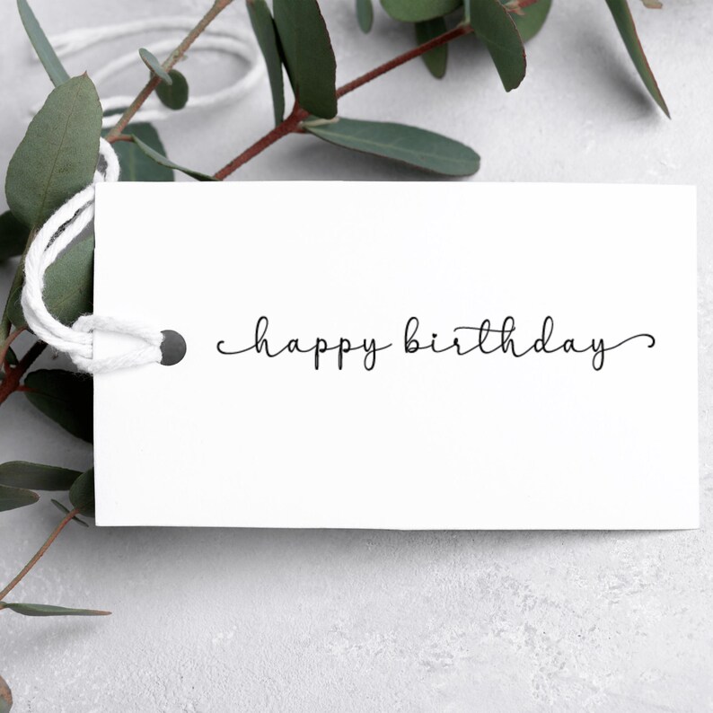 May include: A white gift tag with a black handwritten message that says "happy birthday".