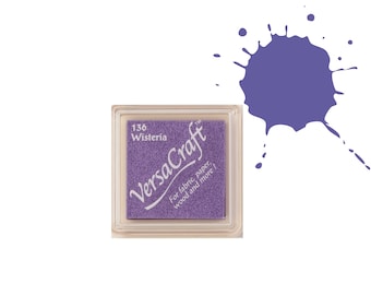 May include: A purple ink pad labeled "136 Wisteria" and "VersaCraft" for fabric, paper, wood and more. A purple ink splatter is shown next to the ink pad.
