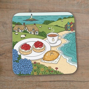 May include: Square coaster with a colourful illustration of a seaside picnic. The image shows scones with jam, a cup of tea, and a pasty on a beach. A lighthouse, cottages, and surfboards are also depicted in the background.