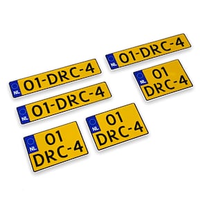 Puede incluir: Cinco placas de matrícula amarillas y azules con el texto "01-DRC-4" y "01 DRC-4" en ellas. Las placas están dispuestas en forma escalonada sobre un fondo blanco.