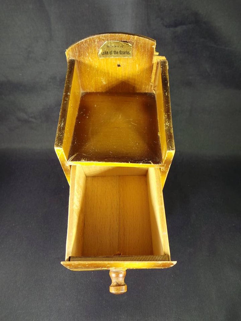 May include: A small wooden box with a drawer. The box has a label that says "Souvenir of Lake of the Ozarks".