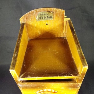 May include: A wooden box with three drawers, each with a different design. The top drawer has a wooden knob and the text "Souvenir of Lake of the Ozarks".