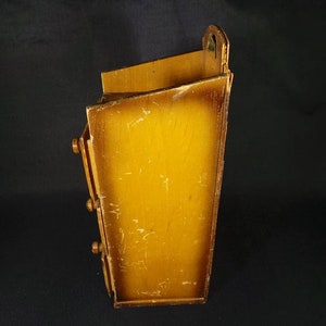 May include: A wooden wall mounted organizer with three drawers. The organizer is stained a light brown color and has a brass handle on the top.