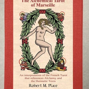 May include: A red and cream-colored tarot card box titled "The Alchemical Tarot of Marseille." The cover features a nude figure within a green wreath, with text below reading "An interpretation of the French Tarot..." by Robert M. Place.