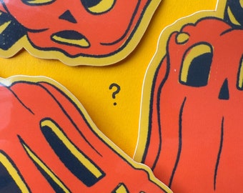 May include: Three orange pumpkin stickers with black and yellow accents are arranged on a yellow surface. Each sticker features a different jack-o'-lantern face. The stickers are likely for Halloween decorations.