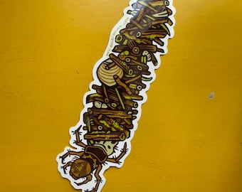 May include: A sticker featuring a stylized insect-like creature carrying a stack of logs. The design incorporates shades of brown, yellow, and green, with the text "www.baileybrown.com" printed on the sticker.