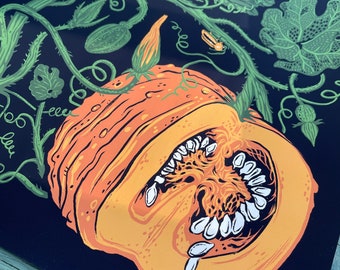 May include: A print featuring a cross-section of an orange pumpkin with white seeds, surrounded by green vines, leaves, and yellow flowers, set against a dark blue background. The artwork has a vintage, botanical illustration style.
