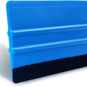 May include: A blue plastic squeegee with a black felt edge. The squeegee has three raised ridges on the blue surface.
