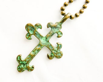Large Antique Bronze Cross with turquoise patina and bone colored bead accent.