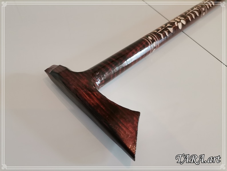 May include: A dark brown wooden walking stick with a carved design and a T-shaped handle.